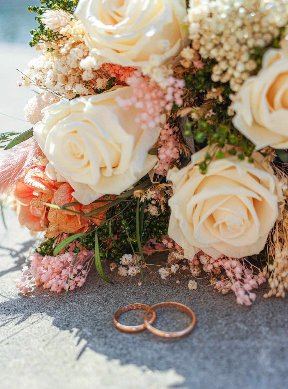 Ramo de rosas preservadas y dos alianzas de boda